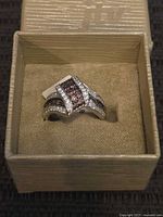 Ring in box showing stone arrangement and tag