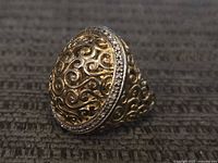 Side view showing filigree scrollwork and pavé stone border