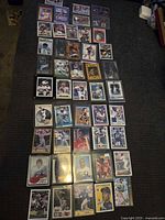 Overview of roughly 40 sleeved sports trading cards laid out on couch