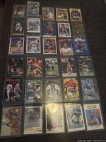 Full sheet of approximately 25 assorted sports cards in sleeves