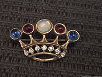 Front view of sterling silver crown brooch showing cabochon stones and rhinestones