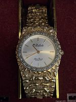 Close-up of watch showing dial, bezel and textured bracelet