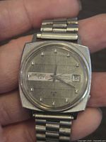 Front view showing Seiko dial, day-date window, indices, and bracelet