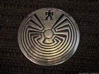 Front of round sterling silver brooch showing labyrinth and figure motif