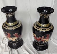 Two black plastic vases with horse motif and stands