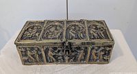 Full view of bronze box showing relief panels and latch