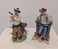 Front view of both ceramic cowboy figurines showing overall design and condition