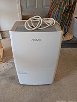 Front view of Noma dehumidifier showing overall condition and attached power cord