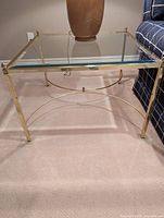 Full view of brass and glass end table showing overall design