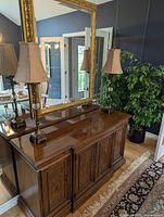 Both matching tall lamps on wooden cabinet, showing overall height and style