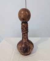 Full view of leather-covered flask showing stopper, braided neck, embossed design