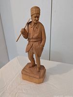 Full view of carved woodcutter figure on base