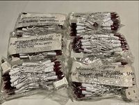Six sealed bundles of white-wire red-bulb string lights in clear plastic