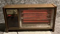 Front view of brown Arvin electric heater showing controls and glowing heating elements