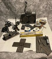 All items laid out showing track pieces, bridge kit, wire reels, speaker unit, remote, locomotive model