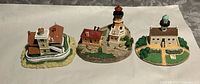 Front angled view of three miniature lighthouse models