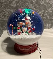 Front view of Gemmy snow globe showing snowman scene and base text