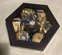 Closed hexagonal box showing six ornaments through window