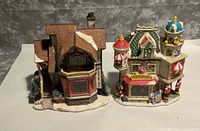 Front three-quarter view of both ceramic village buildings on snow bases