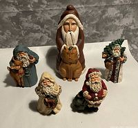 Group shot of all five rustic resin Santa figurines