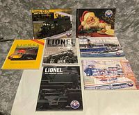 Seven Lionel publications arranged flat showing all covers