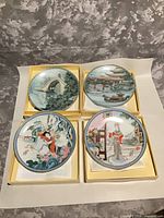 All four boxed porcelain plates displayed