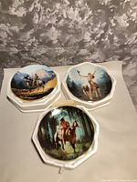 All three Hamilton Collection plates on octagonal foam bases, showing artwork and size