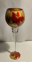 Front view of glass votive goblet showing gold decoupage poinsettia design and clear long stem