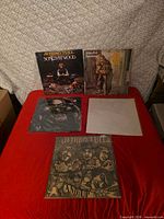 Five Jethro Tull LPs laid out on red surface