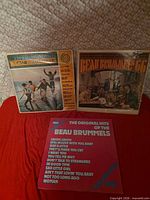 Front covers of all three Beau Brummels vinyl albums on red surface