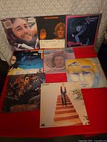 All eight record jackets laid out on red surface
