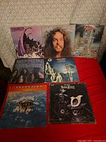 Seven LP jackets laid out on red surface
