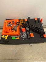 Overview of bench parts, orange tool tray, tools and hardware