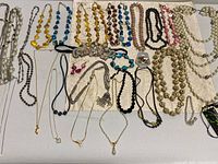 All necklaces laid flat showing variety and weight tag