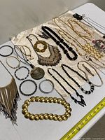 Overview of assorted necklaces and bracelets laid on fabric