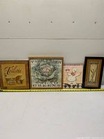 All four framed prints side by side with tape measure for scale
