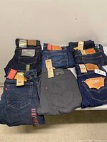 Tabletop view showing all eight pairs of jeans with tags visible