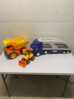 All three toy vehicles on table showing relative sizes