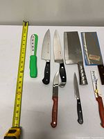 Full group of eight cutting utensils with tape measure for scale
