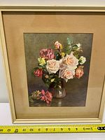 Full view of framed floral print with tape measure showing size