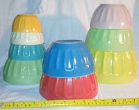 Overview of 9 ribbed ceramic mixing bowls stacked by size and colour