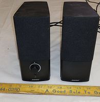 Front view of both Bose speakers showing grilles and volume knob