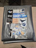 Full view of folded silver tarp with front label