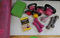 Overall view of kettlebells, dumbbells, yoga block, wrist weight, video, and foam roller
