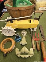 Overall view of lot showing Nelson tractor sprinkler, hand tools, sprinklers, basket, foam kneeler, frog decoration pieces and ring sprinkler