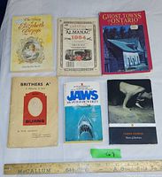 Six paperback books laid out on table