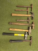 overview of eight hammers laid out on green surface