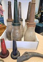 Five glass bottles in box showing spouts