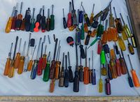 overhead view of assorted screwdrivers spread out on white surface