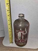 Full view of bottle with cap and tape measure indicating height